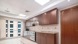 Una cocina amplia con armarios de madera, horno empotrado y un ventanal con vistas a la ciudad.