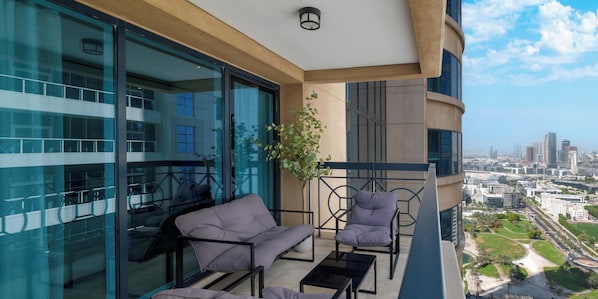 A balcony with modern furniture, a view of the city, and the text "LUX HOLIDAY HOME DUBAI". - LUX The Al Seef Marina Suite 2 (Dubai)