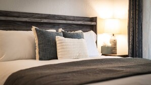 A neatly made bed with a dark headboard, white and grey pillows, and a grey throw blanket. - Heavenly Condo | Walk to Lift | Balcony | Sleeps 6 (Stateline)