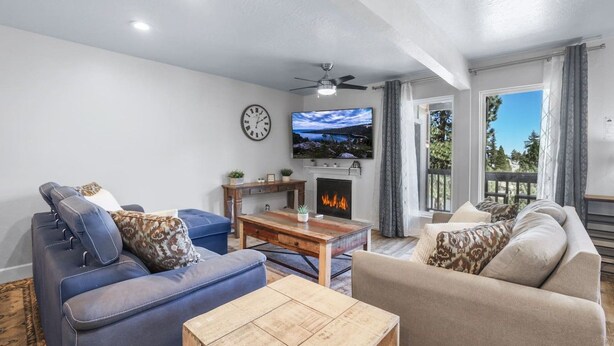 A living room with a fireplace, a television, and a clock on the wall. - Heavenly Condo | Walk to Lift | Balcony | Sleeps 6 (Stateline)