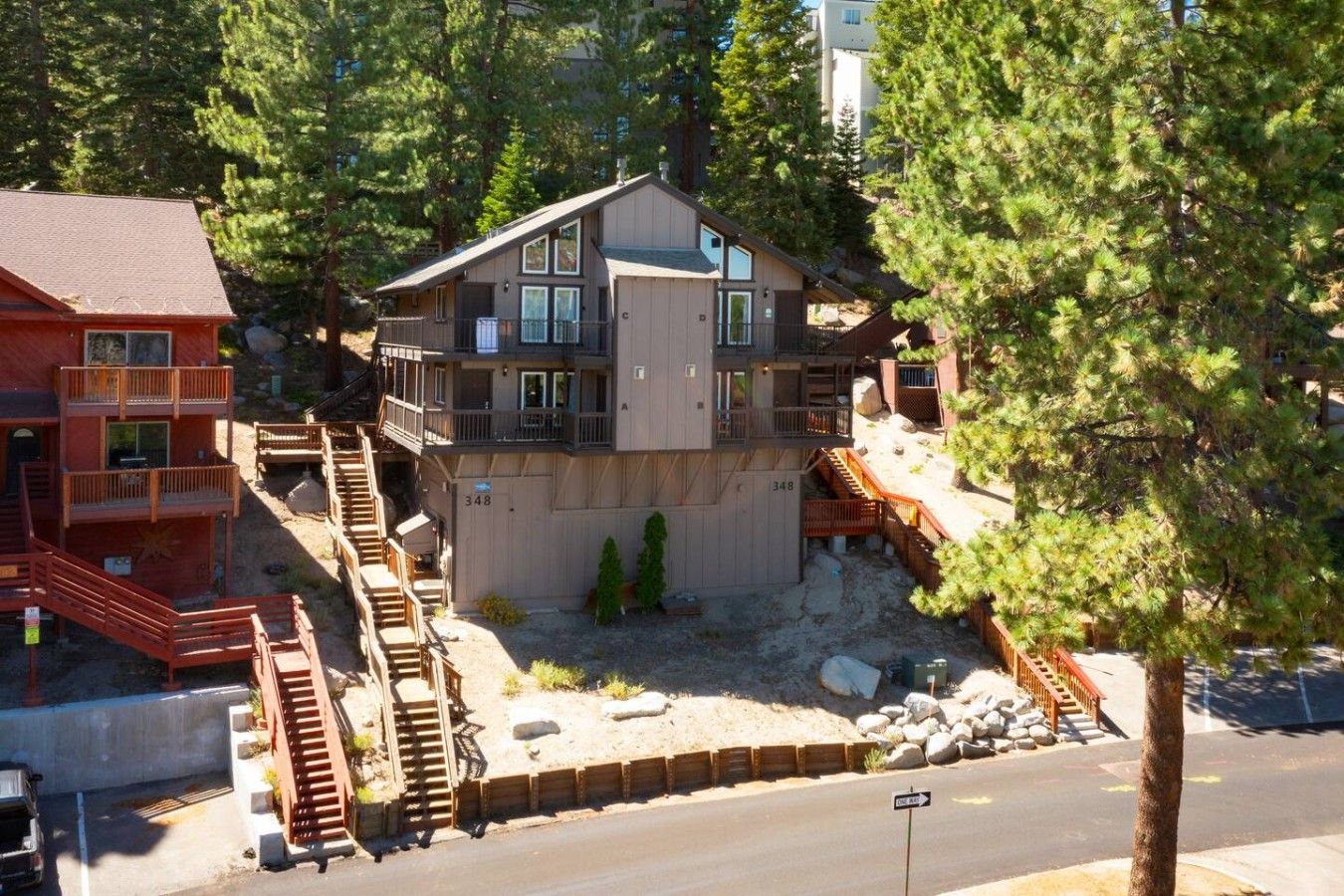 A multi-story building with a balcony, a staircase, and a driveway.