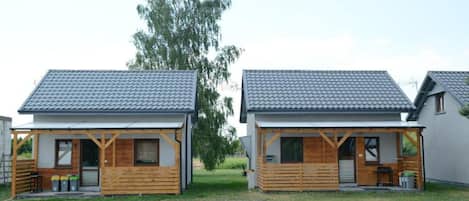 Two small wooden cabins with tiled roofs and wooden front porches.