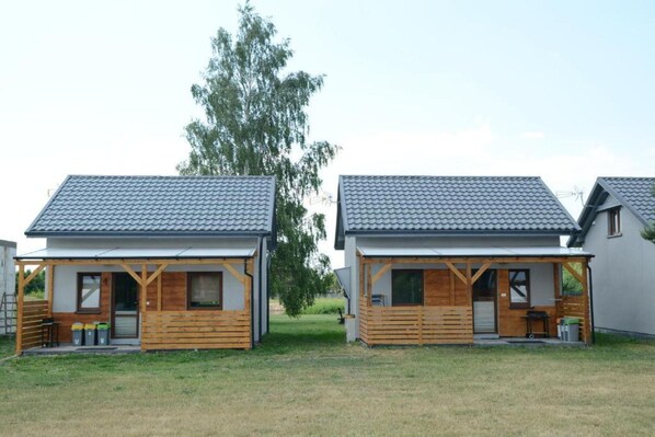 Two small wooden cabins with tiled roofs and wooden front porches.