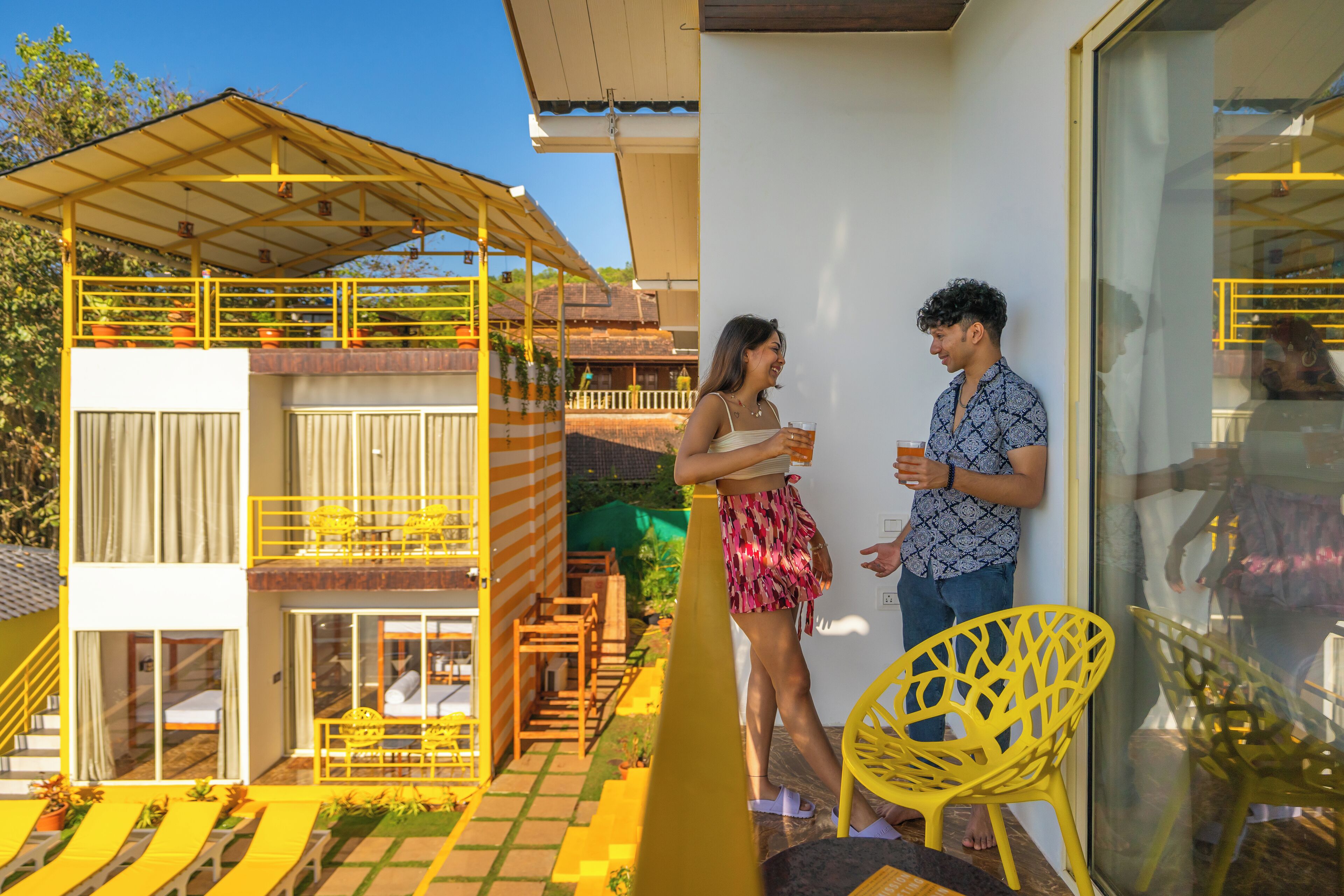 Ein zweigeschossiges Gebäude mit Balkon und Außenbereich zum Sitzen.