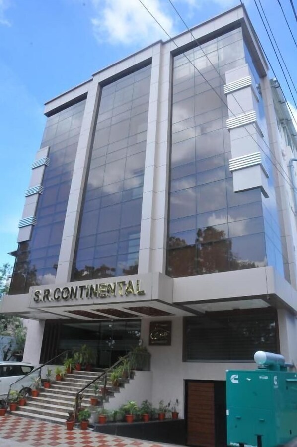A modern building with the sign 'S.R. Continental' on the facade, featuring large glass windows and a staircase with potted plants. - Hotel SR Continental (Gulbarga)