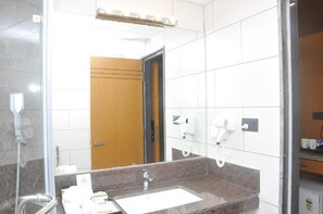 A bathroom with a sink, mirror, hairdryer, and towel rack. - Hotel SR Continental (Gulbarga)