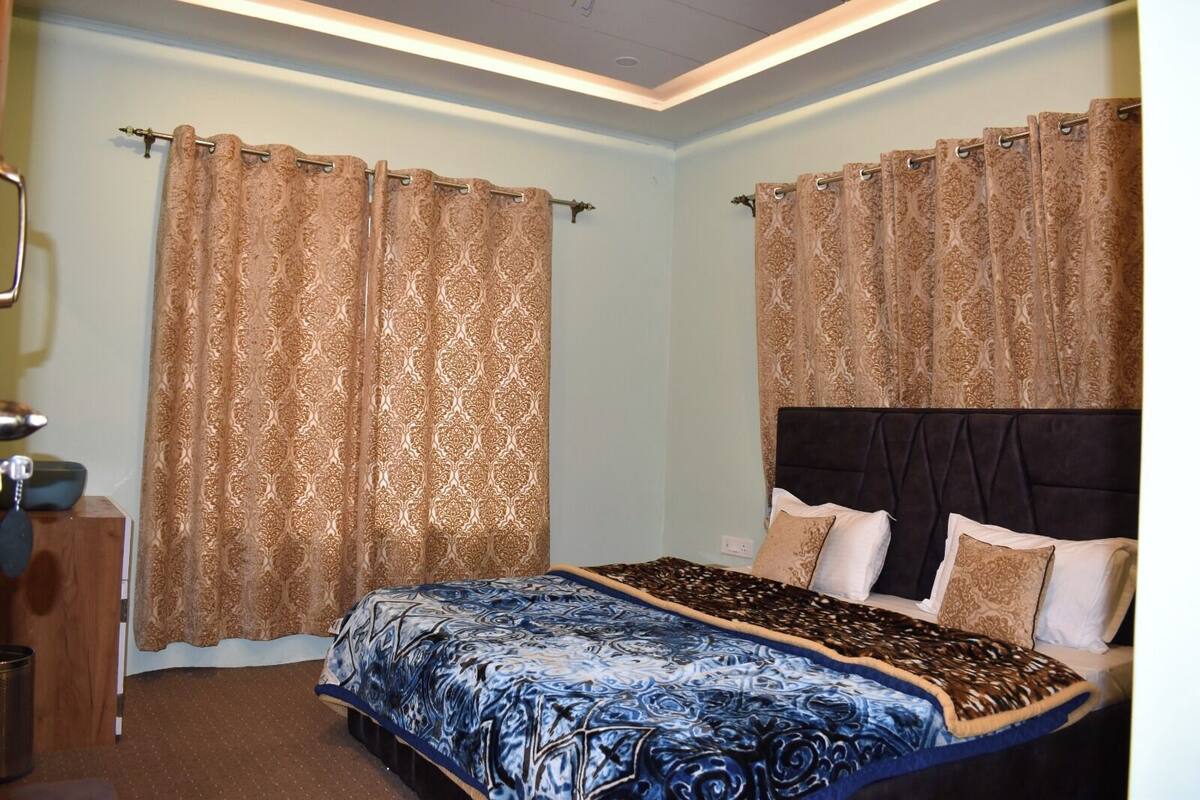 A bedroom with a bed, curtains, and a headboard.