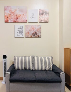 A living room with a sofa, a wall-mounted heater, and four framed motivational quotes. - Tranquil Poolside Balcony (Iloilo City)