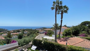 Zona de piscina con sillones de descanso y vista al mar.