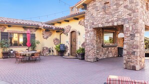 A patio area with a stone building, outdoor seating, and a brick floor. - Sleeps 8, 2 Homes | Vineyard Views, Patios in Temecula Wine Trail (Temecula)