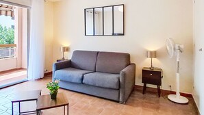 A modern living room with a grey sofa, two side tables with lamps, a floor lamp, and a large mirror on the wall. - Le Clin Foc by Interhome (Six Fours)