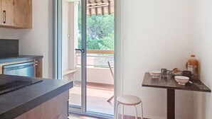 A kitchen with a sliding glass door leading to a balcony. - Le Clin Foc by Interhome (Six Fours)