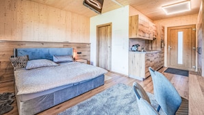 Une chambre moderne avec un grand lit, une table de chevet et un luminaire au plafond.