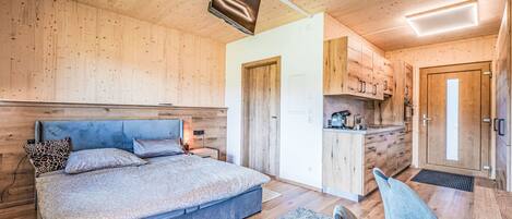 Un dormitorio moderno con una cama grande, una mesita de noche y una lámpara en el techo.