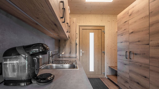 Une cuisine moderne dotée d’une cuisinière intégrée, d’un évier et d’armoires en bois.