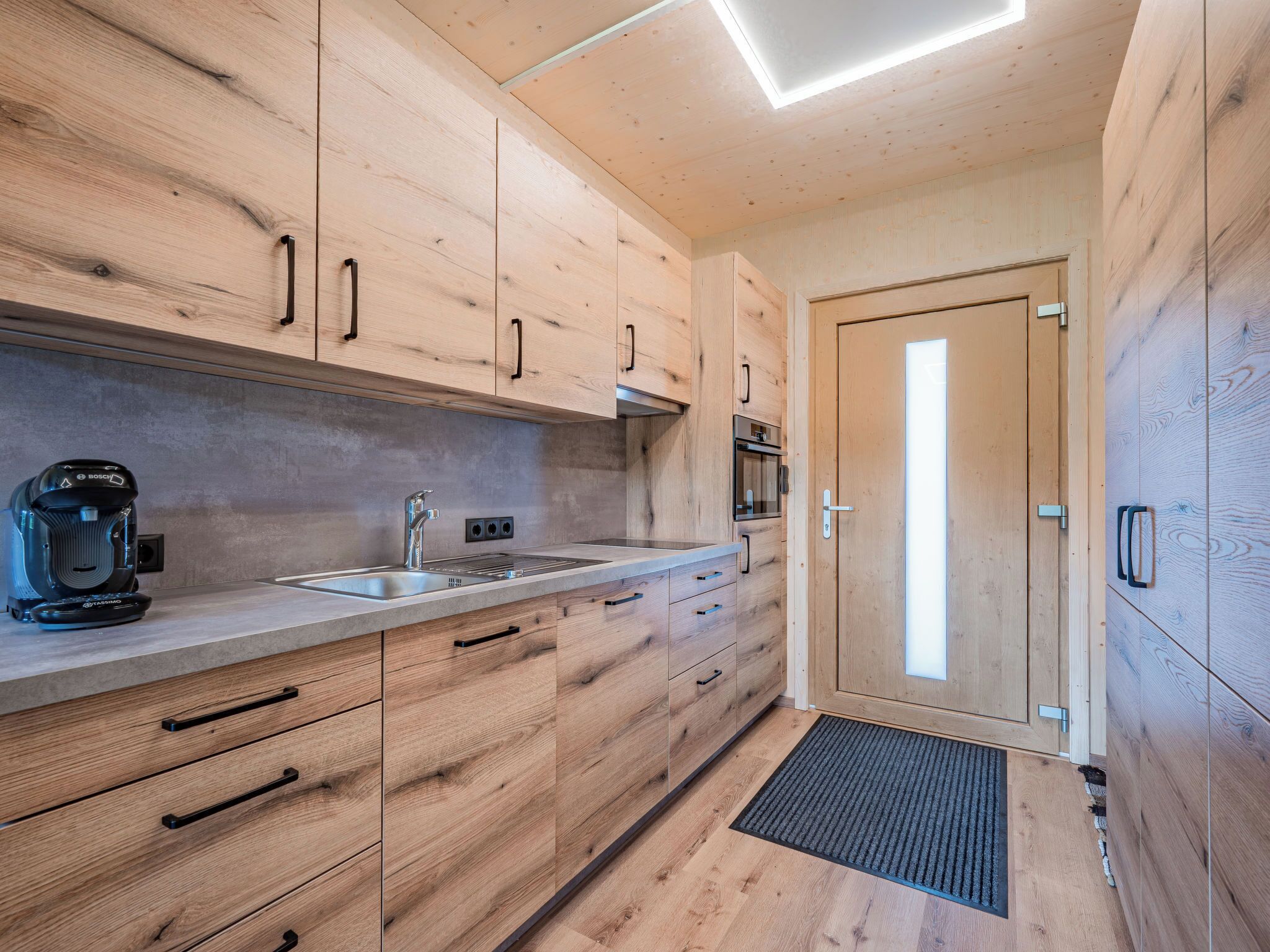 Een koelkast, een oven, een broodrooster, kookgerei, borden en bestek