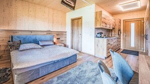 Un dormitorio moderno con una cama grande, una mesita de noche y una lámpara en el techo.