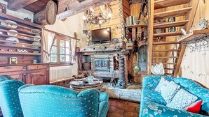 A rustic room with wooden furniture, a chandelier, and shelves filled with various items. - Chalet le Prarion by Interhome (Saint Gervais)
