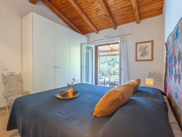 Un dormitorio con cama, ventana y vistas al exterior.