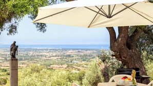 An outdoor seating area with a table, chairs, and a statue.