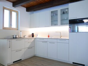 Een koelkast, een oven, een vaatwasser, kookgerei, borden en bestek