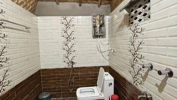 A small bathroom with a toilet, a shower, and a sink.