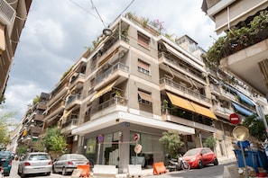 A multi-story building with balconies, a no entry sign, and parked cars. - LIV - Premium Pagrati Apartment With View (Athens)