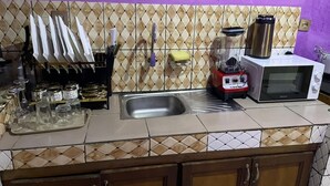 A kitchen with a microwave, a blender, and a sink. - Delightful 2-bedroom apartment with AC in Yaoundé (Yaoundé)