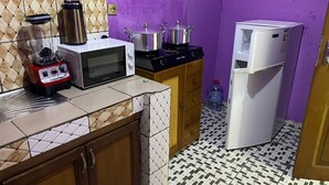 Una cocina compacta con microondas, estufa y refrigerador.