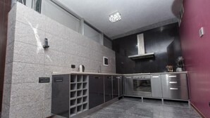 Eine moderne Küche mit Granitarbeitsplatten, Edelstahlgeräten und einem integrierten Weinkühler.