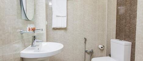 A modern bathroom with a white sink, a toilet, and a shower.