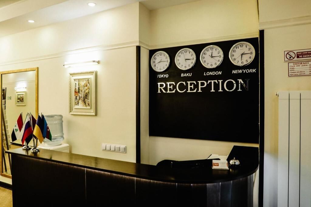 A reception area with clocks displaying Tokyo, Baku, London, and New York times.