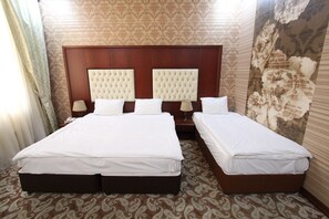 Comfort driepersoonskamer | Luxe beddengoed, een minibar, een kluis op de kamer, een bureau