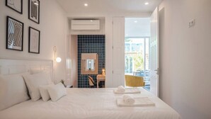Habitación de hotel con una cama grande, un escritorio con silla, una ventana y obras de arte en las paredes.
