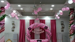 A decorated event space with a stage, balloons, and a banner reading "HAPPY BIRTHDAY". - lvy Hotel And Restaurant (Mukerian)