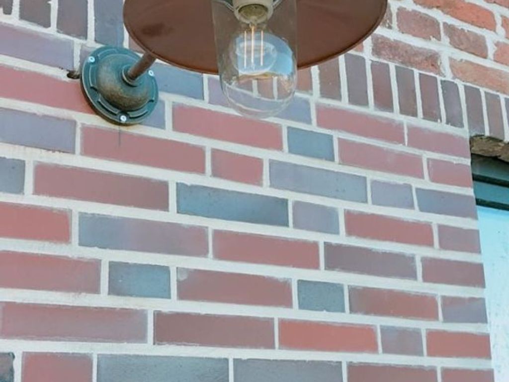 Pared de ladrillo con una lámpara.