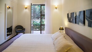 Un dormitorio con una cama grande, una silla, una puerta y una ventana.