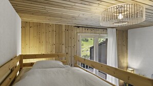 A bedroom with a wooden ceiling, a bed, and a view of the outdoors through a window. - Val d'Illiez, 6 pers • Balcony & view - parking (Val-d`Illiez)