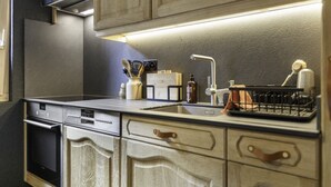 A modern kitchen with wooden cabinets, a stainless steel countertop, a built-in dishwasher, and a range hood. - Val d'Illiez, 6 pers • Balcony & view - parking (Val-d`Illiez)