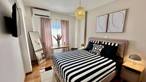 Una camera da letto moderna con un letto grande, comodini, uno specchio e una lampada a sospensione.