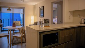 A modern kitchen with a built-in refrigerator, a dining area with a table and chairs, and a view of the outside through large windows. - w* | Comfortable 2BR w/ Private Balcony in San Isidro (San Isidro)