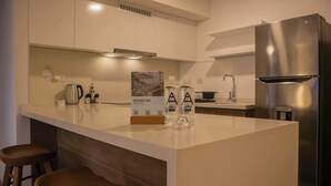 A modern kitchen with white cabinetry, stainless steel appliances, and a central island with stools. - w* | Comfortable 2BR w/ Private Balcony in San Isidro (San Isidro)