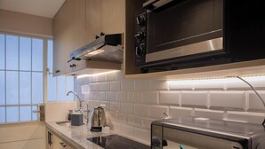 Une cuisine moderne équipée d’un four à micro-ondes, d’une cuisinière et d’une bouilloire intégrés.