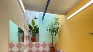 Un escalier dont les murs sont ornés de motifs géométriques, agrémenté de plantes en pot et doté d’une main courante.