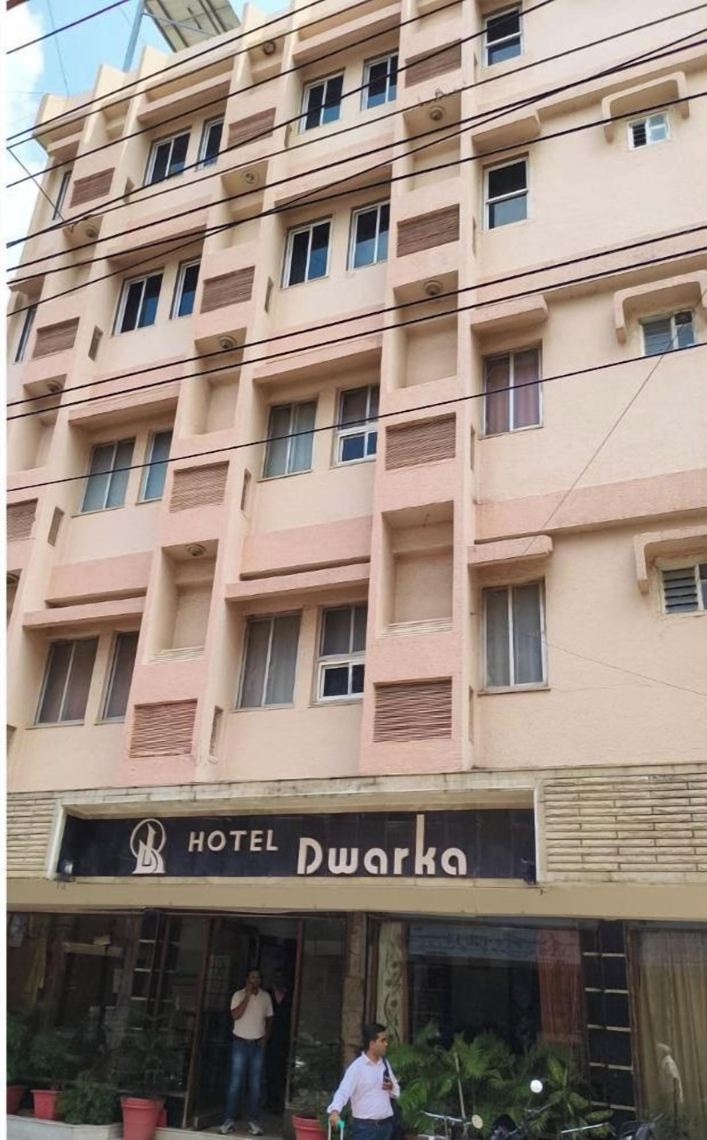Un edificio de hotel de varios pisos con un letrero que dice 'HOTEL Dwarka'.