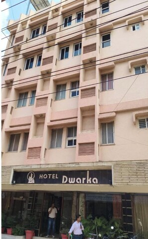 A multi-story hotel building with a sign reading "HOTEL Dwarka."