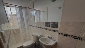 A bathroom with a toilet, sink, and shower. - Hostal El Auqui (Cusco)