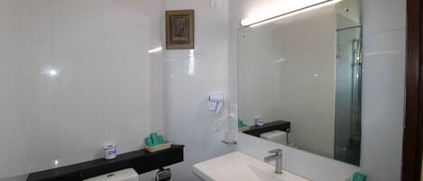 Un baño con inodoro, lavamanos y espejo.