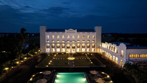 A large, white building with multiple arched windows and a central courtyard with a pool. - Kynrock Hotels & Resorts (Kataragama)