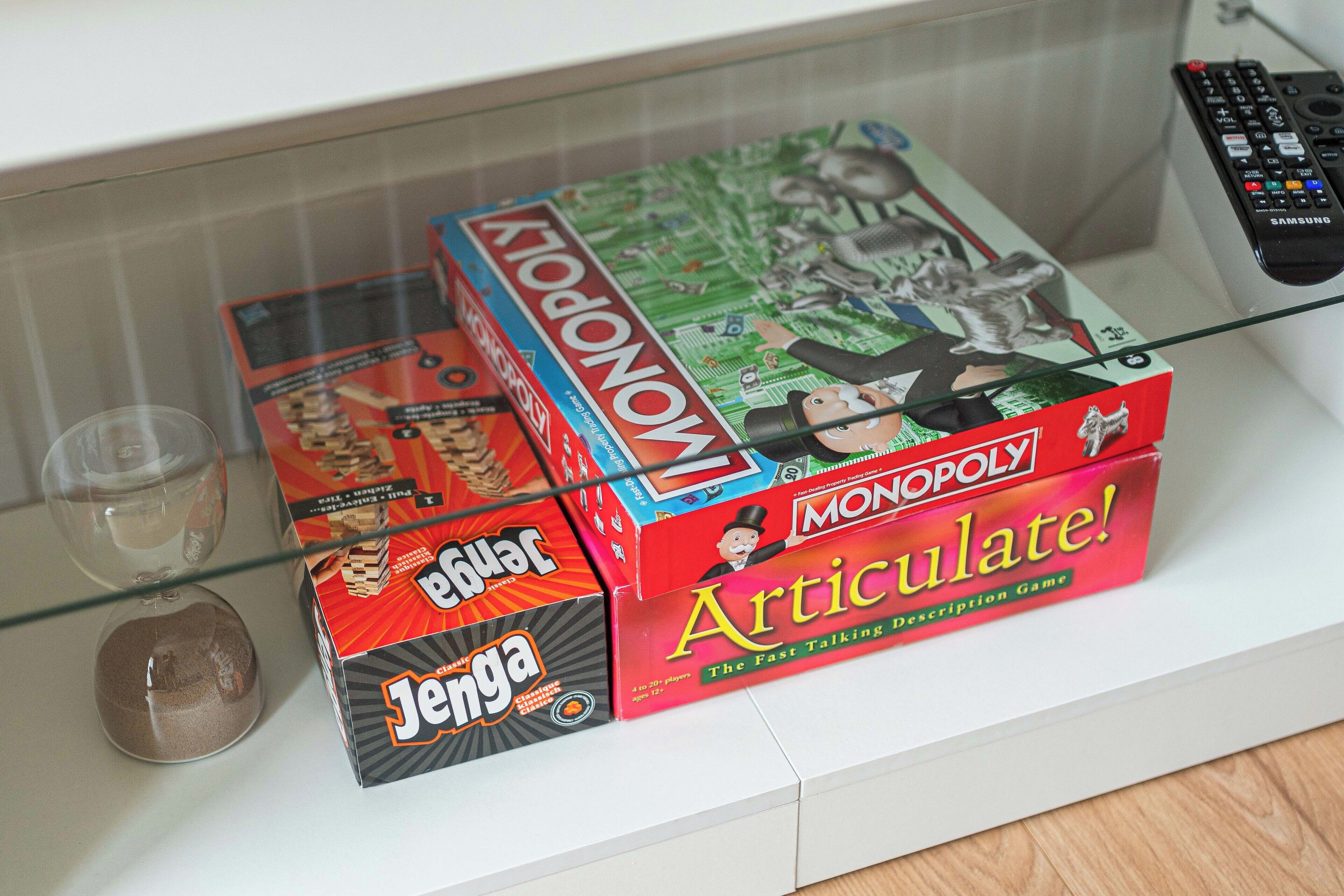 Een glazen vitrine met gezelschapsspellen, waaronder Monopoly en Jenga.
